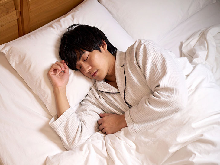 ベッドで眠る若い男性