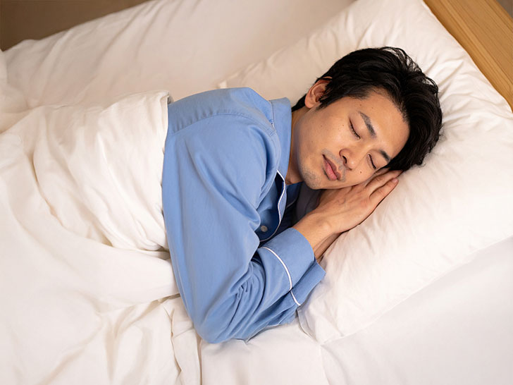 ベッドで眠る若い男性