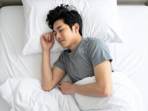 ベッドで眠る若い男性