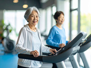 ジムのウォーキングマシンで歩くシニア女性