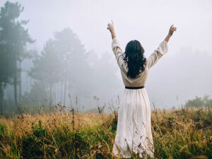 森の中に佇む若い女性の後ろ姿