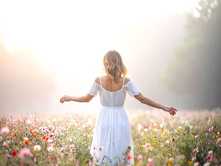 森の中に佇む若い女性の後ろ姿