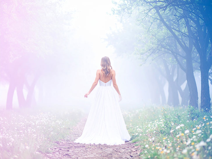 森の中に佇む若い女性の後ろ姿