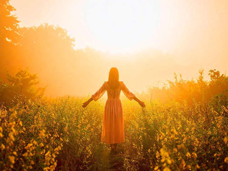 森の中に佇む若い女性の後ろ姿