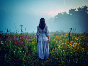 森の中に佇む若い女性の後ろ姿